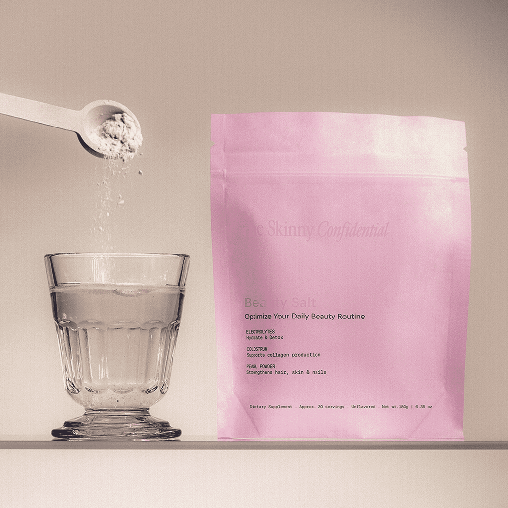The Skinny Confidential Beauty Salt pink packaging with glass and spoon.